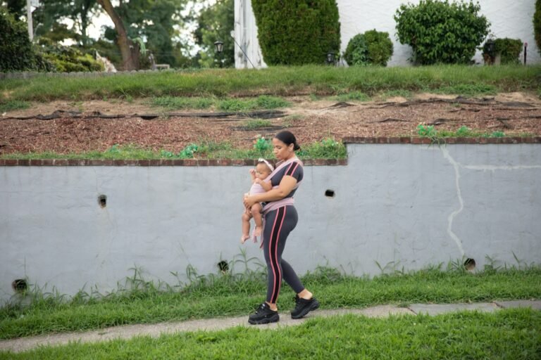 a man holding a baby by a pond