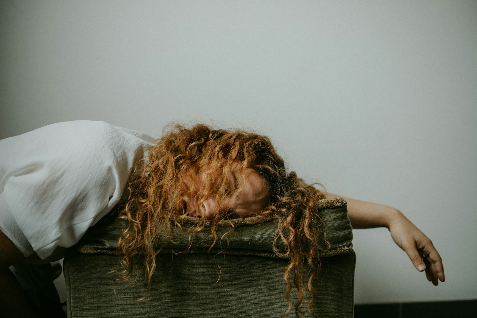 woman in white shirt lying on black textile